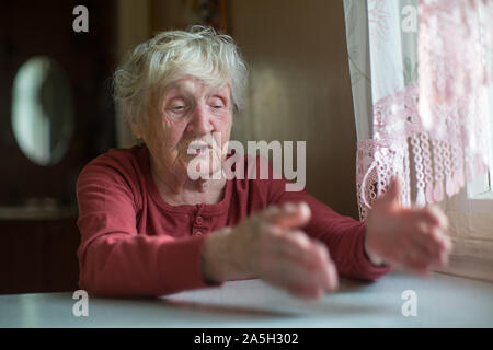Ältere Frau reagiert emotional durch Erzählen und gestikulierend. Stockfoto