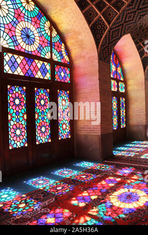 Schönen Mustern von Sonnenlicht auf Teppichen durch bunte Glasfenster. Innenraum der Nasir al-Mulk Moschee (Rosa) Moschee in Shiraz, Iran Stockfoto