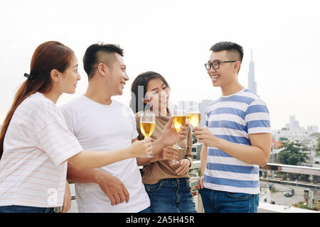 Gruppe von Mitarbeitern stehen auf dem Dach des Büro- und klirren mit Champagner Gläser Stockfoto