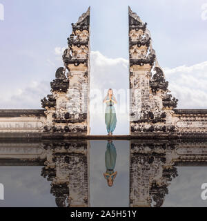 Junge Frau im Tempel Gates in Lempuyang Luhur Tempel auf Bali, Indonesien. Vintage Ton. Bali, Indonesien, Reisender, der an der Alten Stockfoto