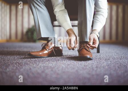 Nahaufnahme eines Mannes, der seine Schuhe bindet und bekommt Bereit für ein Geschäftstreffen Stockfoto