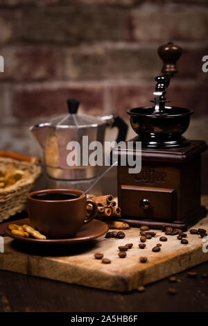 Vintage Kaffeemühle, Tasse mit einem Getränk und gerösteten Bohnen Stockfoto