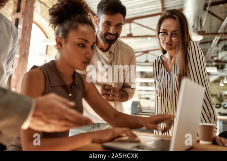 Anstrengenden Arbeitstag. Geschäftsleute auf den Laptop beim zusammen im modernen Büro arbeiten Stockfoto