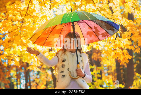 Kind unter einem Sonnenschirm im Herbst Park. Selektive konzentrieren. Stockfoto