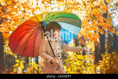 Kind unter einem Sonnenschirm im Herbst Park. Selektive konzentrieren. Stockfoto