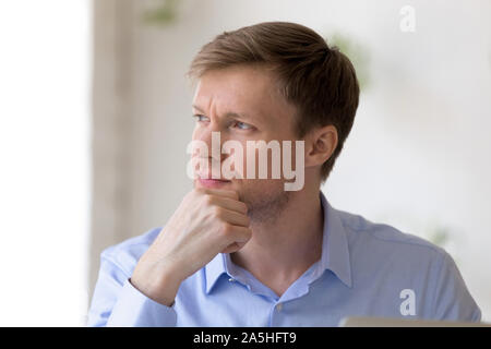 Nachdenklicher Mann, der komplizierte unternehmerische Entscheidung, das Lösen von Problemen. Stockfoto