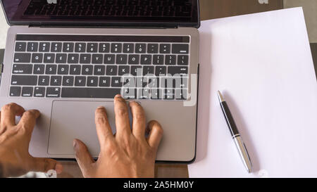Arbeiten an der Tastatur. Hohe Betrachtungswinkel und Nahaufnahme. Ansicht von oben direkt über. Hände berühren und Texteingabe auf einem Laptop Tastatur. Wirtschaft Finanzen und Industrie, onlin Stockfoto