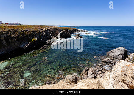 Kristallklare Bucht, wo Sie unten durch Sie sehen kann und einen Teil des Dorfes 'Porto Covo' auf seinem Felsen thront. Stockfoto