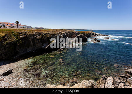 Kristallklare Bucht, wo Sie unten durch Sie sehen kann und einen Teil des Dorfes 'Porto Covo' auf seinem Felsen thront. Stockfoto