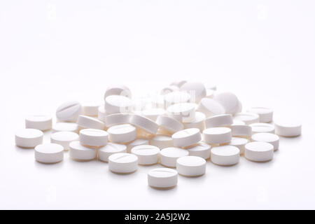 Stillleben mit Haufen runde Pillen oder Tabletten, Antidepressiva oder Schmerzmittel mit Platz für Text. Auf weissem Hintergrund. Stockfoto