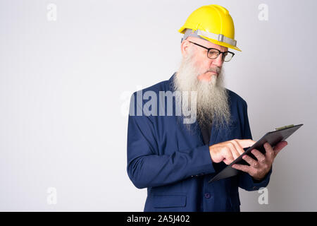 Reife bärtige Geschäftsmann als Ingenieur Lesung über Zwischenablage Stockfoto