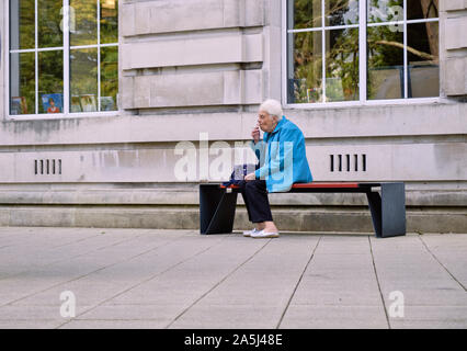 Ältere Dame eine Pause rauchen außerhalb vor dem Betreten des Belfast Nichtraucher Museum Stockfoto