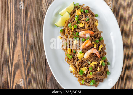 Schüssel, Pad Thai - Thai gebratene Reisnudeln auf dem hölzernen Hintergrund Stockfoto