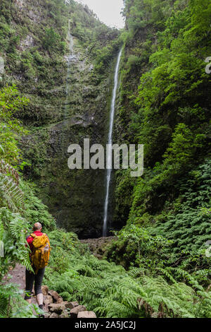 Touristische männlichen Wandern zu erreichen "Caldeirao Verde" Wasserfall am Wanderweg "Caldeira Verde", Santana, Insel Madeira, Portugal Stockfoto