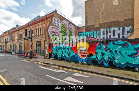 LONDON SPITALFIELDS HÄUSERREIHE WORKSHARE SANTANDER FAHRRÄDER UND BILD AUF EINE WAND VON BORIS JOHNSON Stockfoto