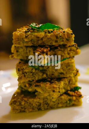 Dhokla ist ein vegetarisches Essen los, dass aus dem indischen Bundesstaat Gujarat verursacht wird. Es ist mit einem fermentierten Teig von Reis gemacht und Split chic Stockfoto