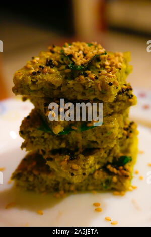 Dhokla ist ein vegetarisches Essen los, dass aus dem indischen Bundesstaat Gujarat verursacht wird. Es ist mit einem fermentierten Teig von Reis gemacht und Split chic Stockfoto