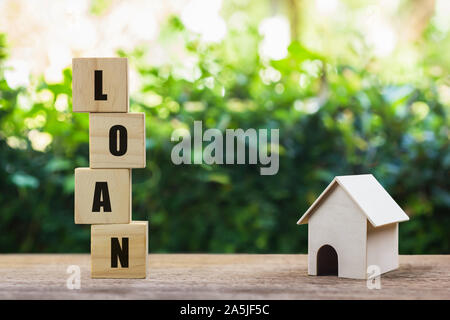 Geld sparen, Darlehen, Hypothek, eine Eigenschaft Investition für zukünftige Konzept. Ein Block aus Holz auf Holz Tisch gestapelt mit einem kleinen Haus Modell. Eine susta Stockfoto