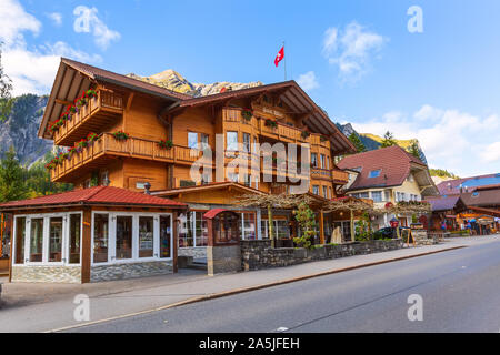 Kandersteg, Schweiz - 17. Oktober 2019: Street View mit bunten Holzhaus, Schweizer Flagge und Berge Panorama, Kanton Bern, Europa Stockfoto