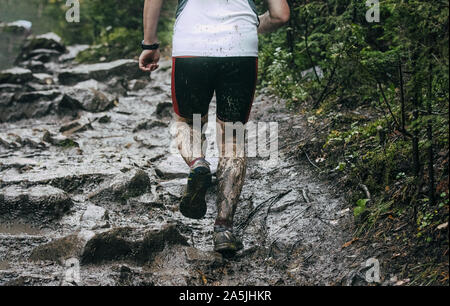Zurück man Läufer laufen Herbst Mountain Trail durch Schlamm und Wasser Stockfoto