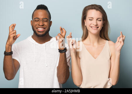 Abergläubische multiethnischen Paar kreuz Finger machen möchten Stockfoto