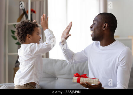 Happy ethnischen Vati geben hohe fünf kleinen Sohn danken. Stockfoto