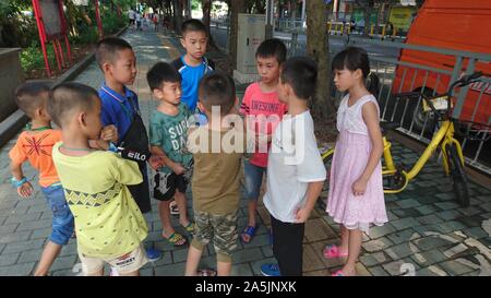 Eine Gruppe von chinesischen Kindern über 8 Jahre alt sind, spielen im Straße Stockfoto