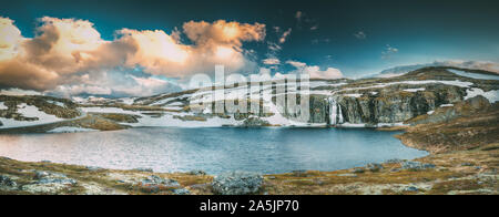 Straße Aurlandsfjellet, Norwegen. Wasserfall Flotvatnet im Frühjahr verschneiten Landschaft. Scenic Route Straße im Sommer norwegischen Landschaft. Norwegische Wahrzeichen und Stockfoto