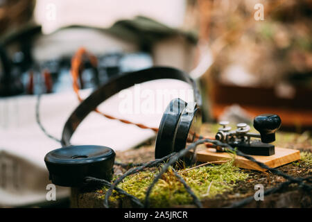 Russisch-sowjetischen Tragbares Radio Transceiver von udssr Red Army Signal Corps im Zweiten Weltkrieg verwendet. Kopfhörer und Fernschreiber Key sind auf einem Baumstumpf. Stockfoto