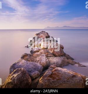 Pier/Steg von Fels und Stein, playa de muro, Alcudia, Mallorca, Spanien, Sonnenaufgang über Berge, schöne glatte Meer. Stockfoto