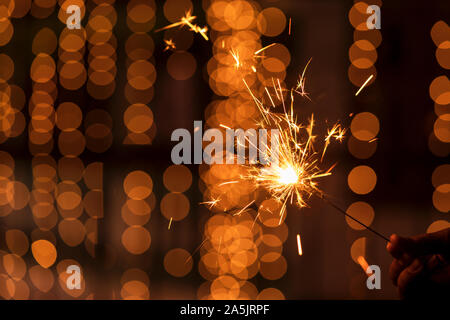 Happy Diwali - Beleuchtung eine Wunderkerze. Modell Holding sparkler Konzept für die festliche Jahreszeit Diwali, dhanteras, Weihnachten, Neujahr feiern Hintergrund. Stockfoto