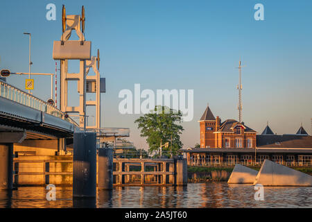 Kampen, Niederlande - 7. Mai 2018: Stadsbrug und Bahnhof in Kampen, Niederlande, im goldenen Licht Stockfoto