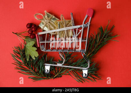 Das neue Jahr Geschenke mit Garn in Spielzeug Warenkorb mit Kiefernzweigen und hawthorn Beeren auf roten Hintergrund. Stockfoto