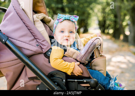 Adorable Baby im Kindersitz auf weißem Hintergrund Stockfoto