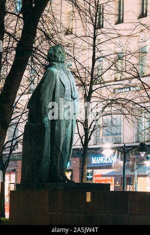 Helsinki, Finnland - 8. Dezember 2016: Abendlicher Blick von Denkmal für Finnische Dichter und Journalist Eino Leino im Esplanade Park. Stockfoto