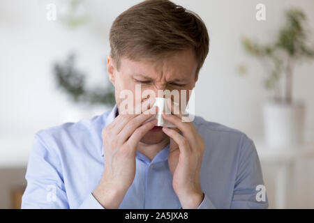 Kopf geschossen ungesunde Geschäftsmann mittleren Alters leiden unter laufende Nase. Stockfoto