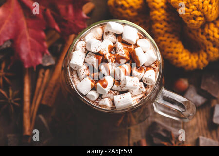 Tasse heiße Schokolade mit Marshmallows gekrönt mit Schokoladensauce und Zimt. Wohlig warmes Getränk, Herbst Komfort Essen. Ansicht von oben, getönten Bild Stockfoto