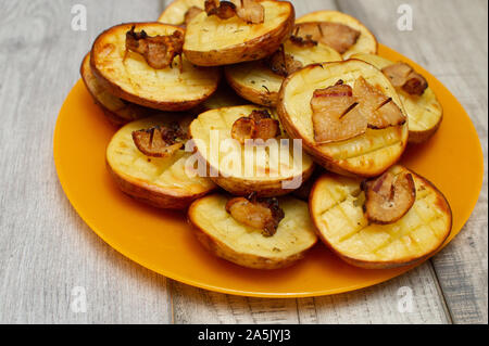 Gebackene Kartoffeln mit Speck. Gebackene Kartoffel mit Schmalz. Halbiert gebackene Kartoffel mit Scheiben von gehackten Speck mit Gewürzen. Food-fotografie. Kochen vegetarisches Stockfoto
