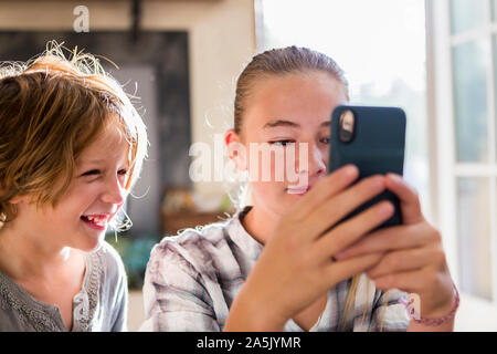 Ein Bruder und eine Schwester, die bis ein smart phone. Stockfoto