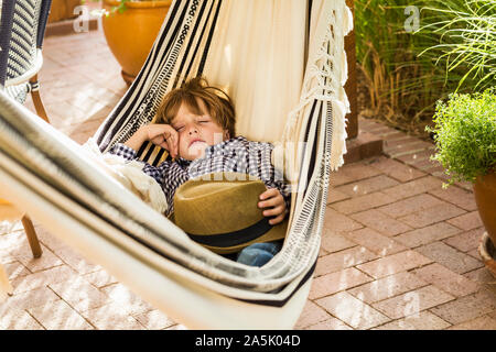 Portrait von 6 Jahre alten Jungen liegen in der Hängematte auf der Veranda Stockfoto