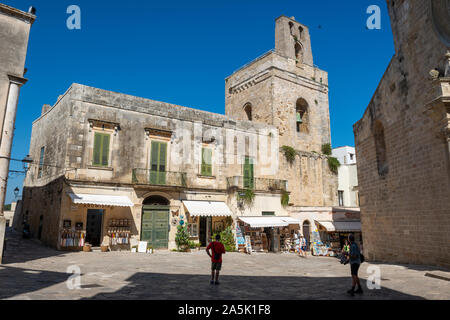 Souvenir Geschäfte auf der Via Basilika mit Glockenturm der Kathedrale von Otranto im Hintergrund - Otranto, Apulien (Puglia) im südlichen Italien Stockfoto