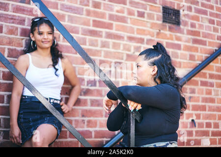 Junge Frau und ihre Schwester im Teenageralter am Notausgang Stockfoto