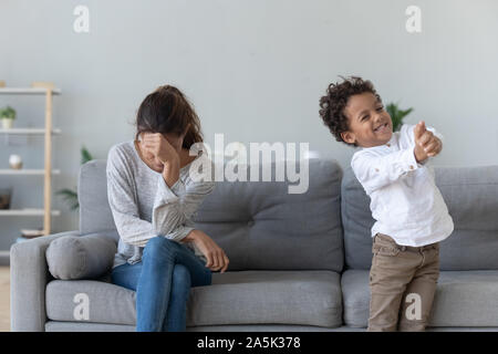 Betonte Mutter erhalten durch Freche kleine Sohn genervt Stockfoto