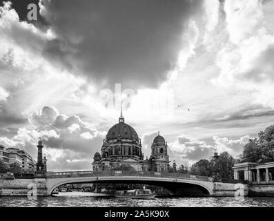 Super schwarz-weiß Blick auf die Kathedrale von Berlin, Deutschland und der Spree gegen einen dramatischen Himmel während einer Flusskreuzfahrt Stockfoto