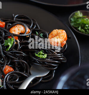 Tintenfisch schwarze Spaghetti mit Garnelen und Tomaten Nahaufnahme Stockfoto