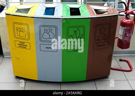 Bunte recycling Bins für Papier, Karton, Tetrapak, Abfälle, Glas, Plastik, Dosen, organische und ein Feuerlöscher Stockfoto