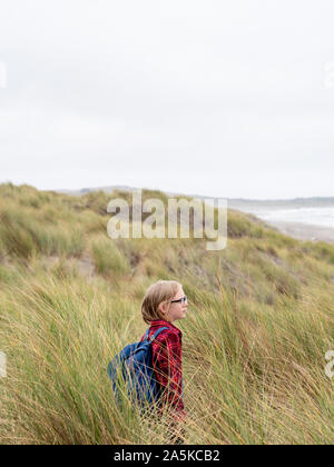 Tween Junge im hohen Gras am Strand Stockfoto