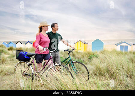 Mitte nach Paar mit Fahrrädern an der Küste, Southwold, Suffolk, Großbritannien Stockfoto