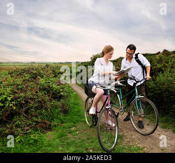 Mitte nach Radfahren Paar auf ländlichen Dirt Track auf Karte, Southwold, Suffolk, Großbritannien Stockfoto