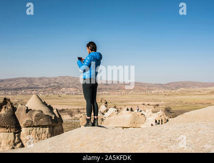 Frau machen Fotos von Fairy Chimney, Göreme in Kappadokien, Nevsehir, Türkei Stockfoto